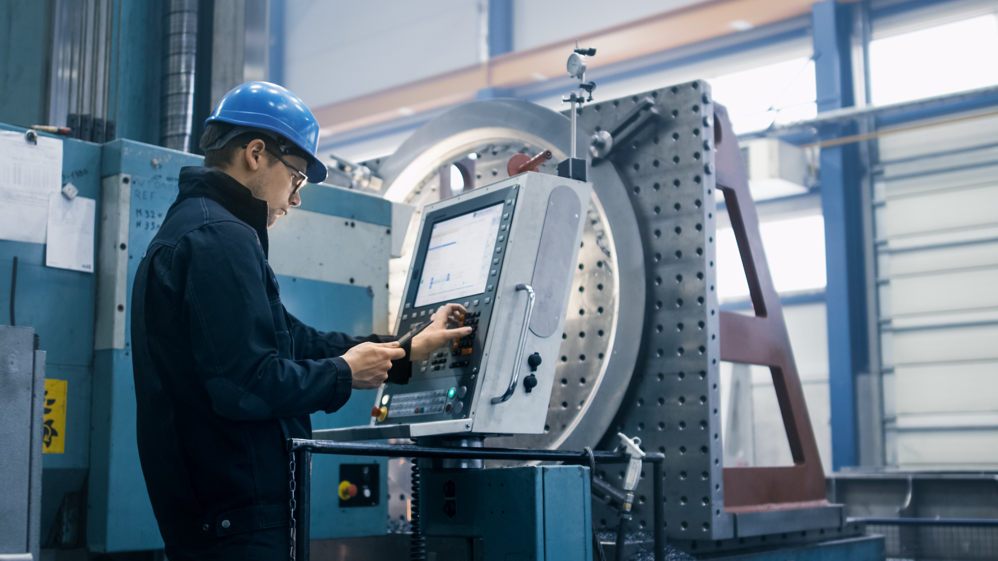 Machine operator using a touchscreen control panel on the shop floor